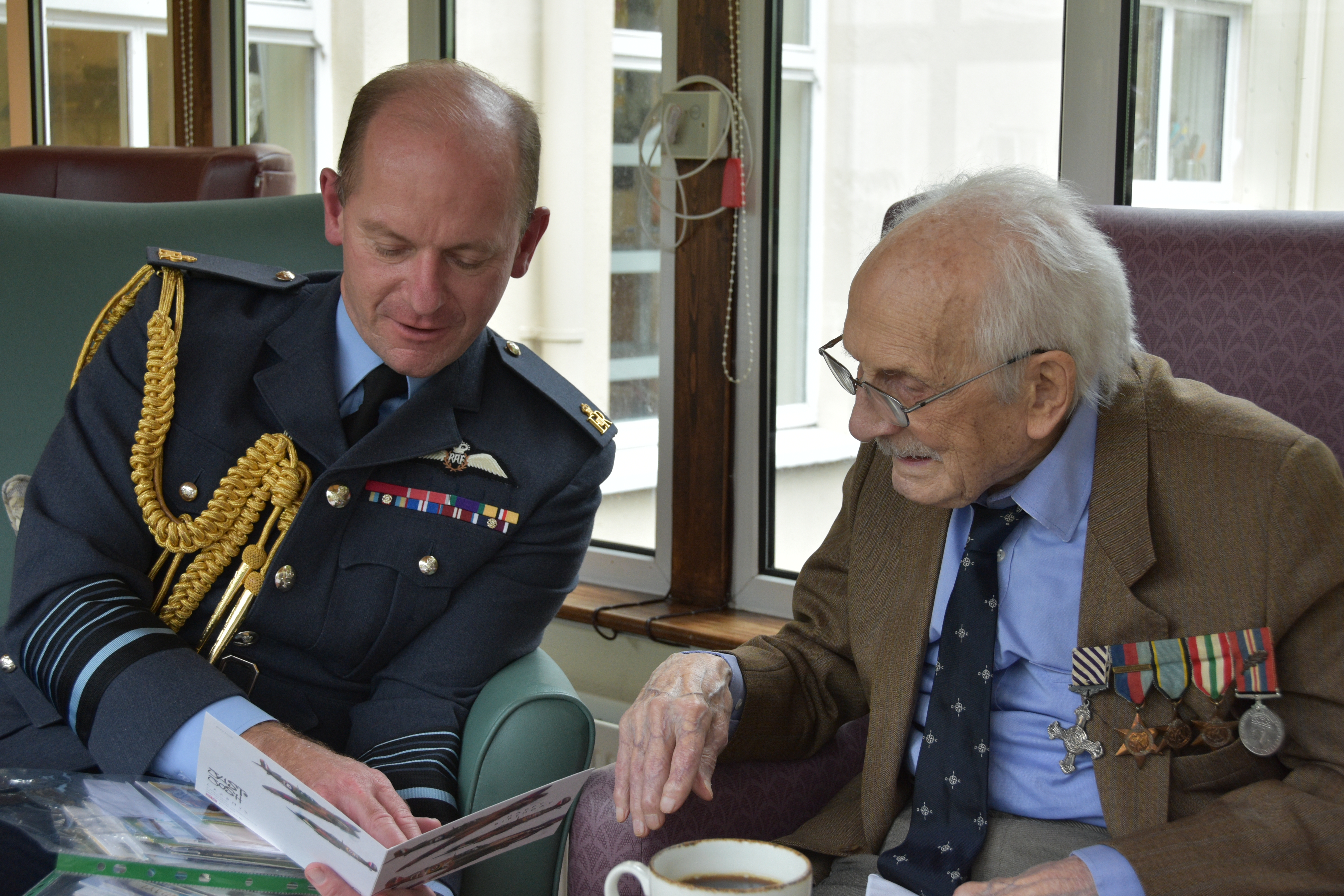 Group Captain (retired) John ‘Paddy’ Hemingway and Air Chief Marshal Sir Mike Wigston read book.